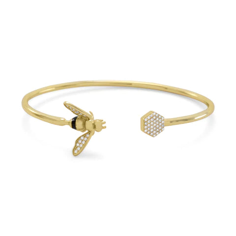 14 karat gold plated sterling silver cuff bracelet with honey bee and honeycomb ends. The CZ honeycomb is 8mm. The bee is 12mm x 19.5mm and its' wings are embellished with Signity CZs. The hollow tube flex cuff bracelet is 2.5mm.  .925 Sterling Silver